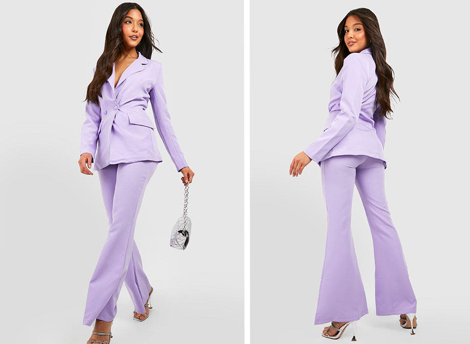 A woman wearing a purple suit, with silver high heels and a silver bag