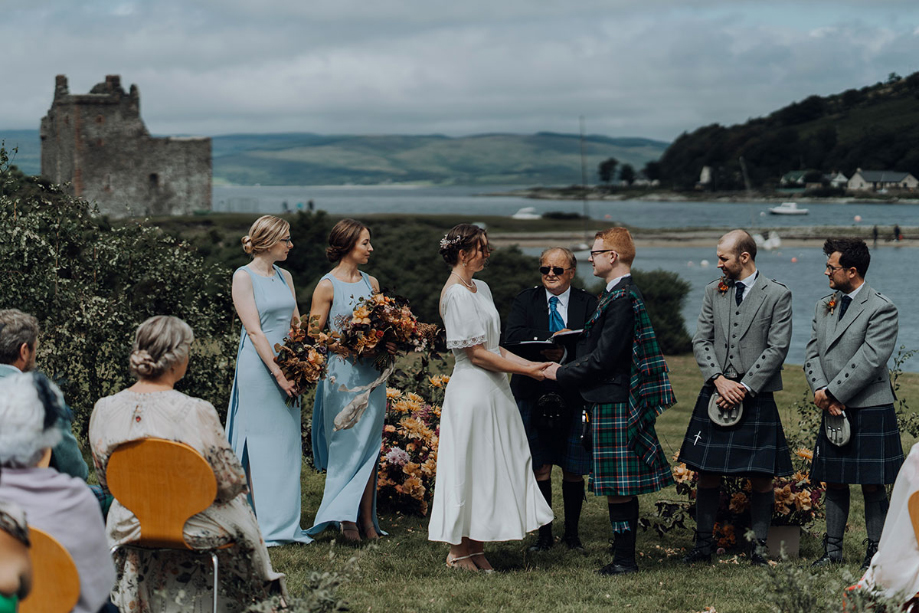 Bride and groom hold hands during the ceremony
