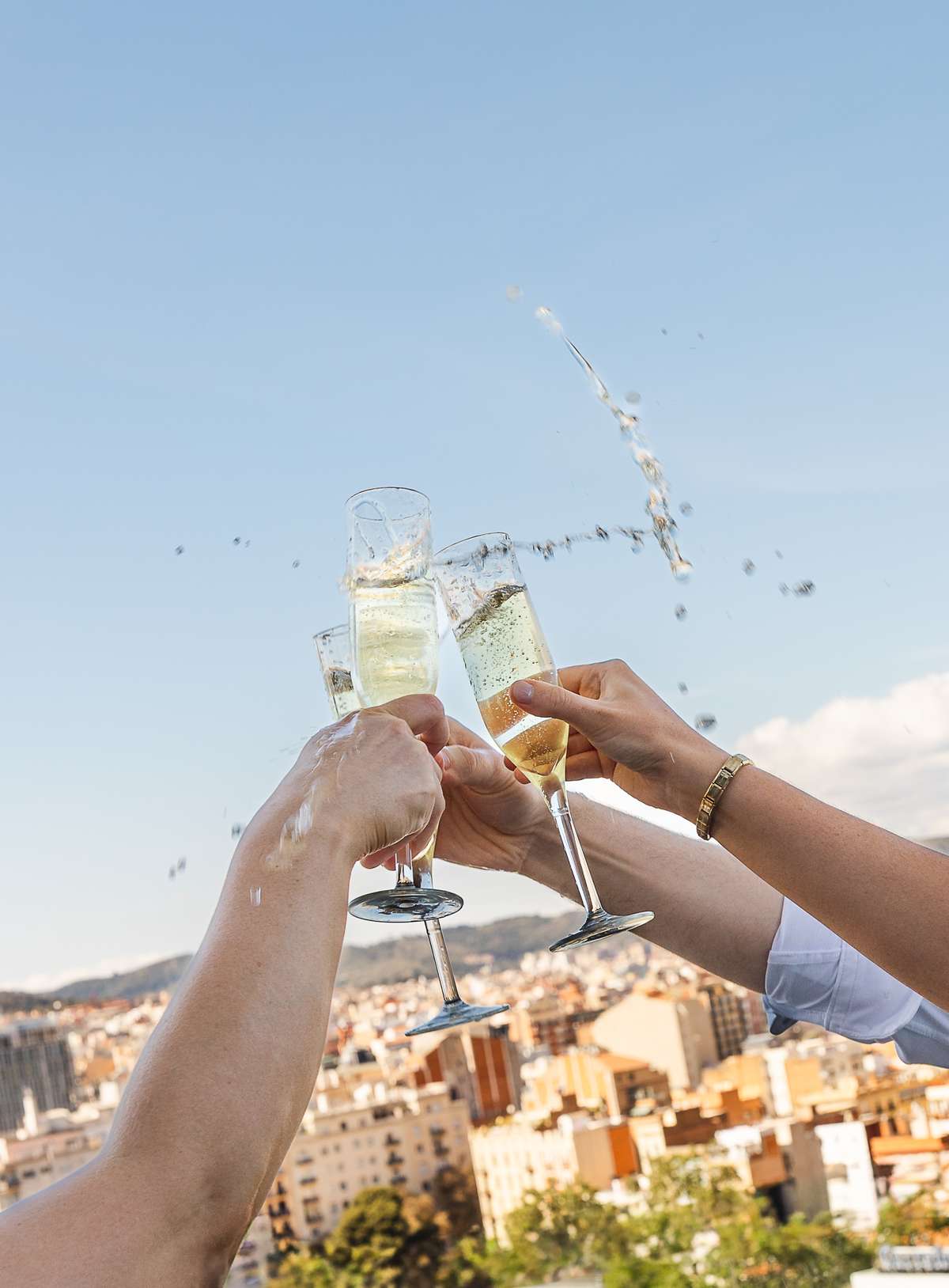Wedding guests clink glasses of champagne during the rooftop wedding celebration at The Hoxton Barcelona, overlooking the city.