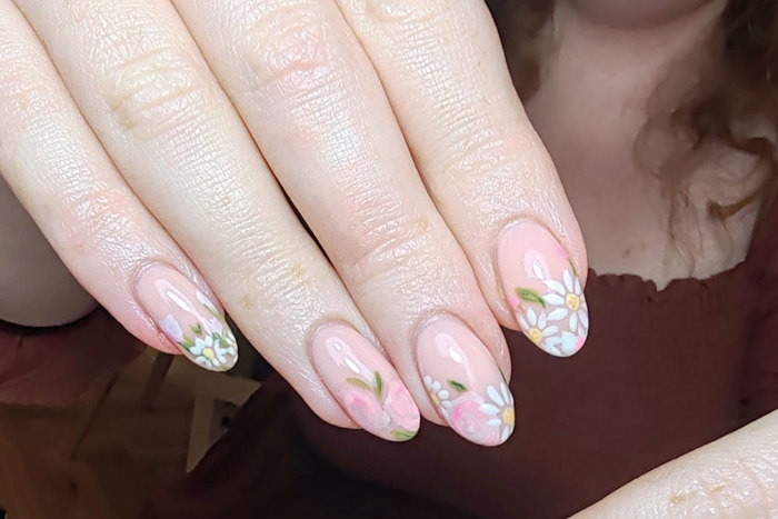 floral painted nails held up to the camera 