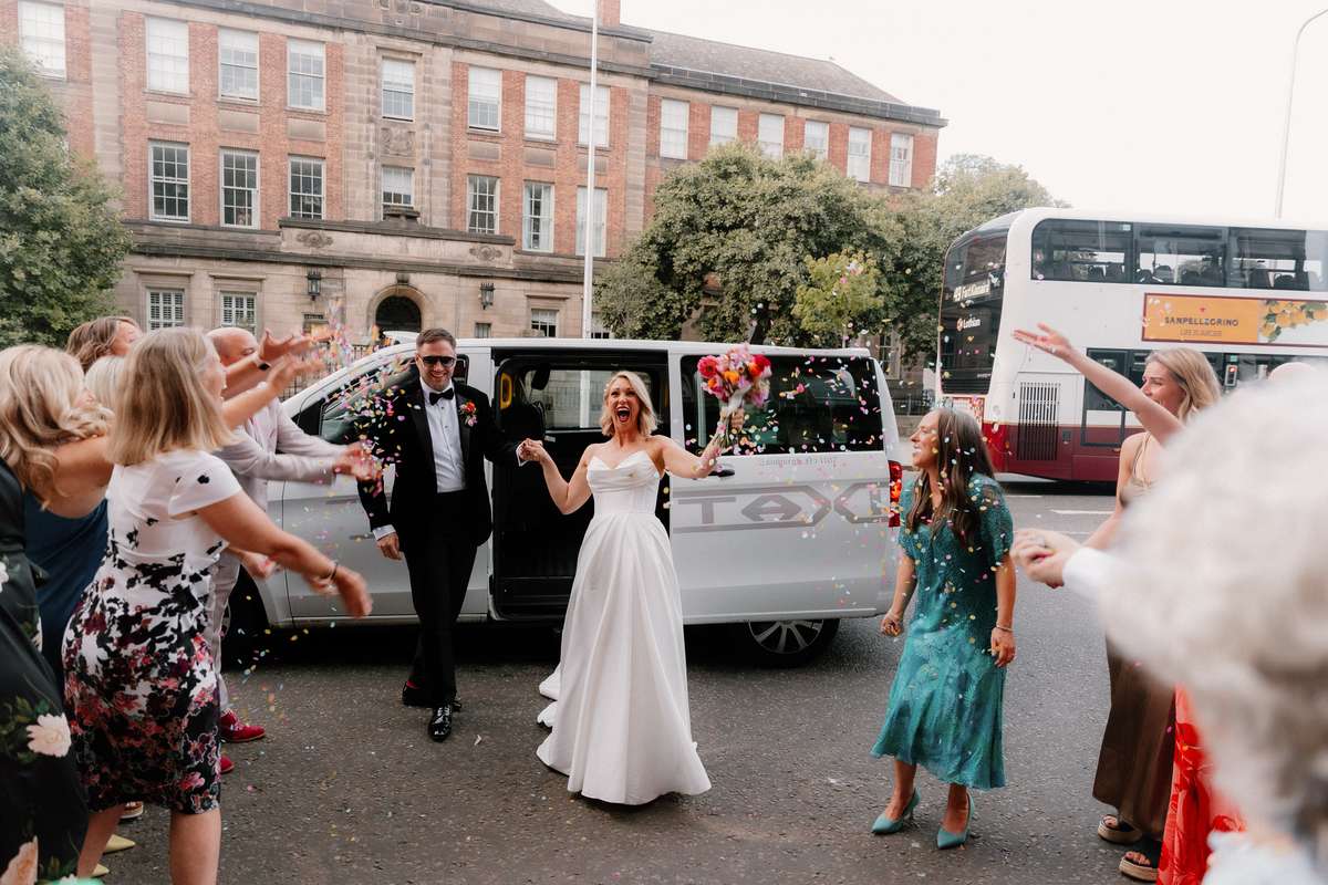 Kara and Rory arrive at their Nauticus wedding reception in Leith as guests welcome them with colourful confetti.