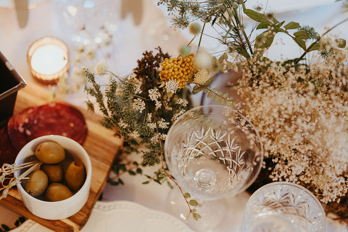 Close-up of elegant wedding table styling featuring crystal glassware, grazing elements and delicate seasonal florals at Cambo Country House.
