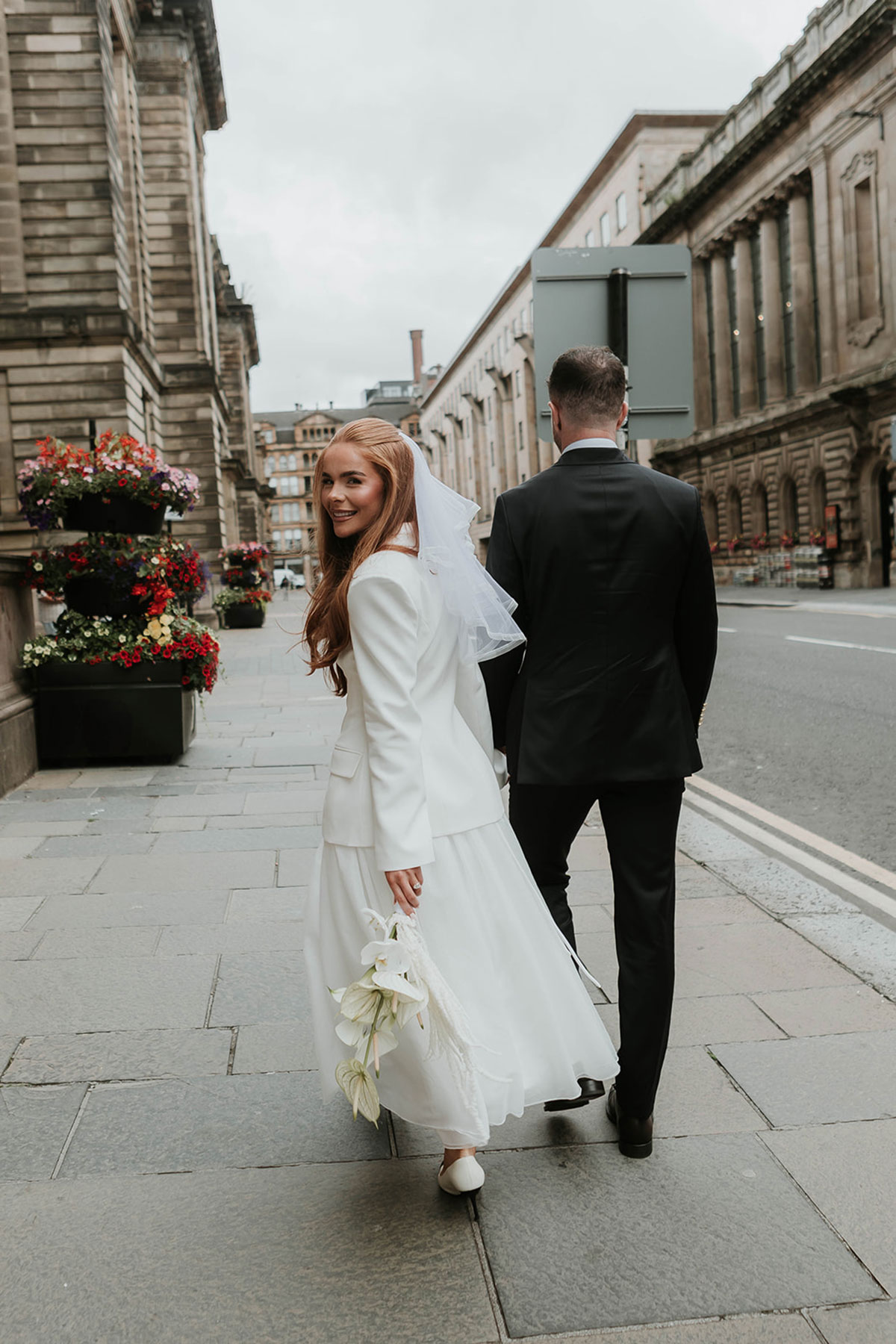 Bride and groom walking down glasgow street
