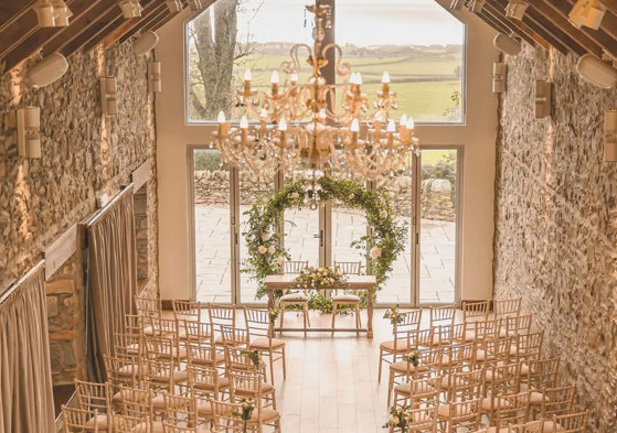 overhead view of ceremony space with circular green arch at the top of the aisle and two sides of rows of wooden chairs