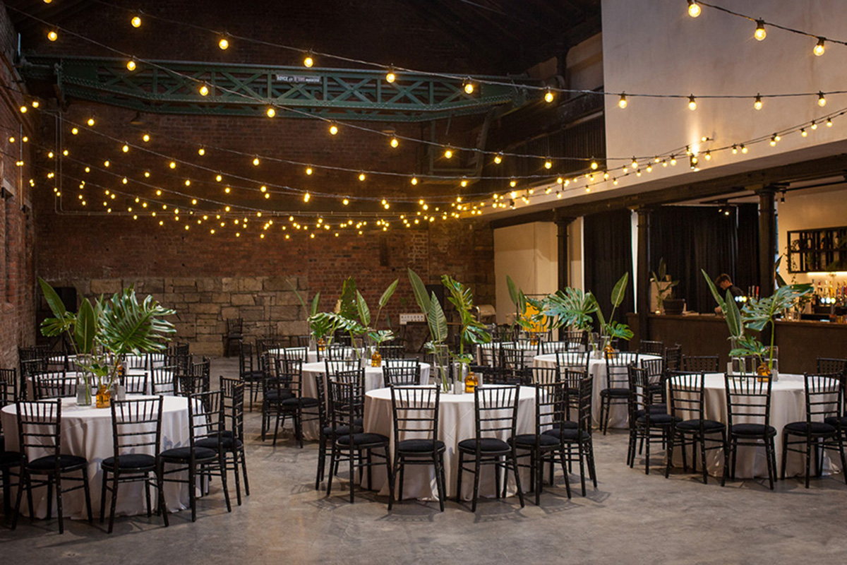 The dining room set up at Engine Works with tables, chairs and fairy lights