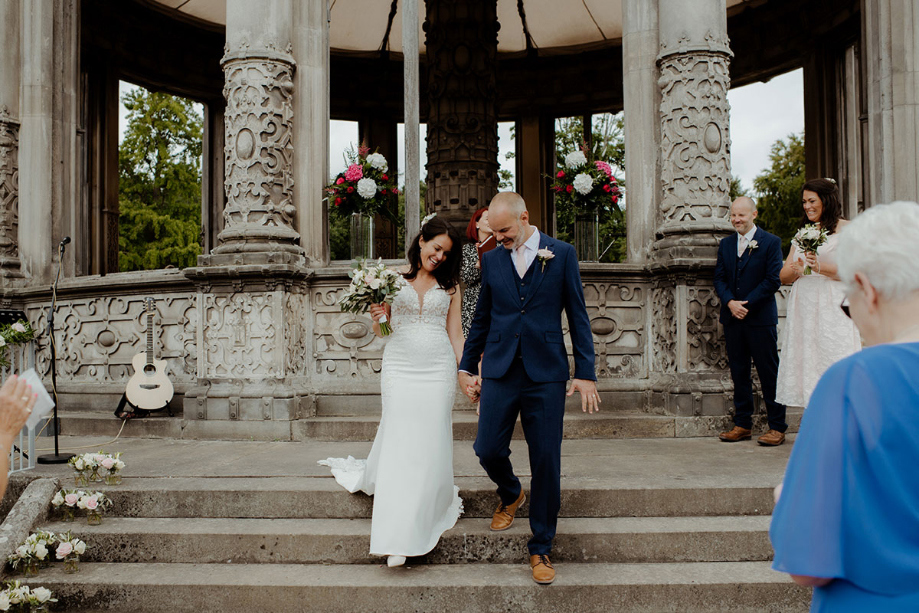 Bride and groom walking on steps of Orangery