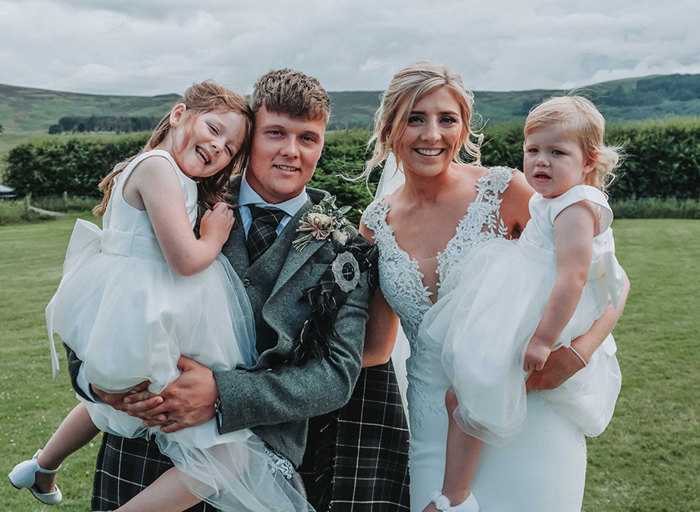 a family portrait of a bride, groom and their two young daughers