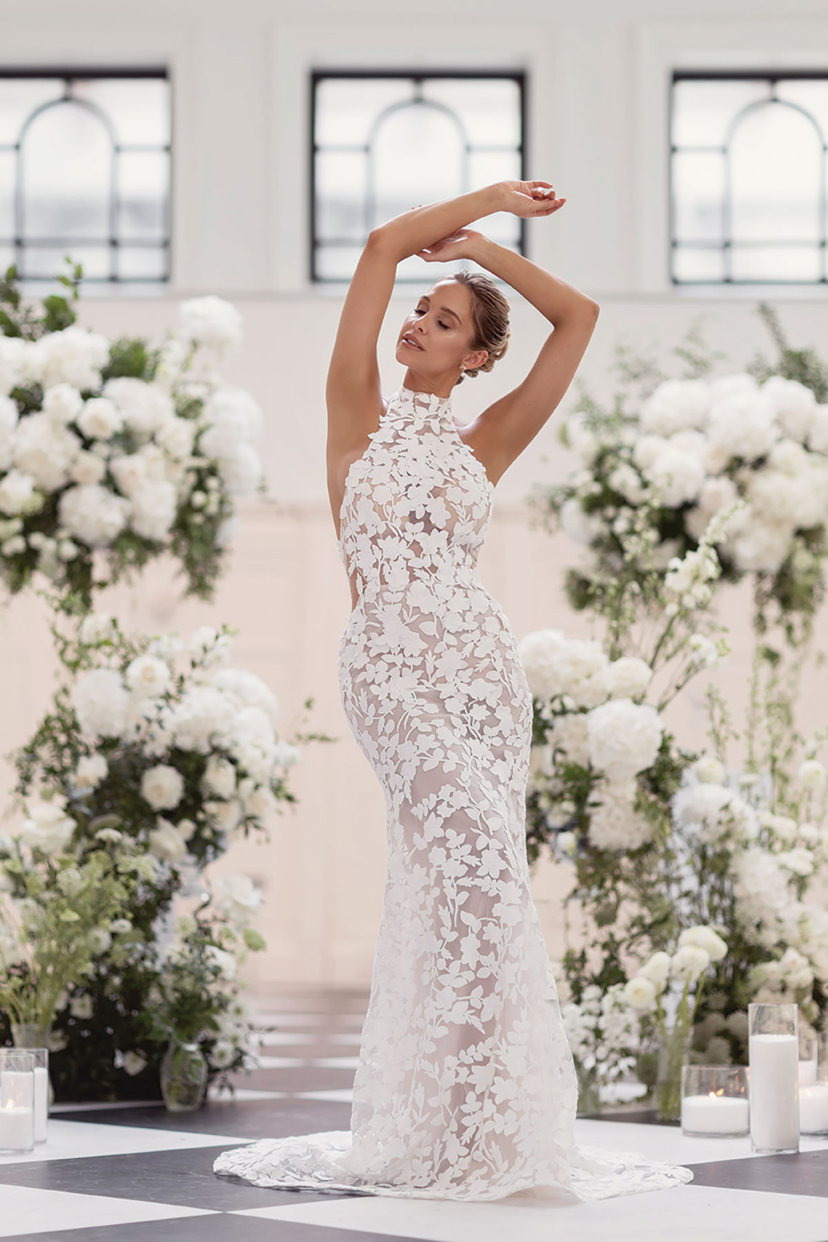 Bride posing with arms raised, wearing a lace applique halterneck wedding gown during styled shoot at The Collector’s Hall