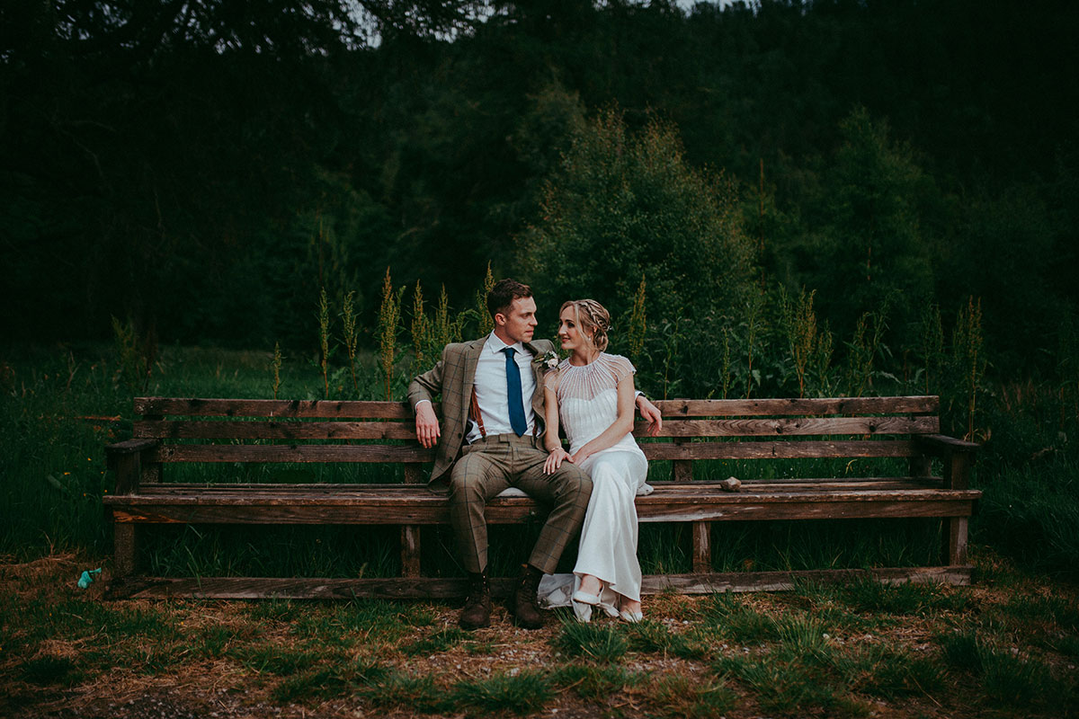 bride and groom sitting on bench at wedding at mar lodge