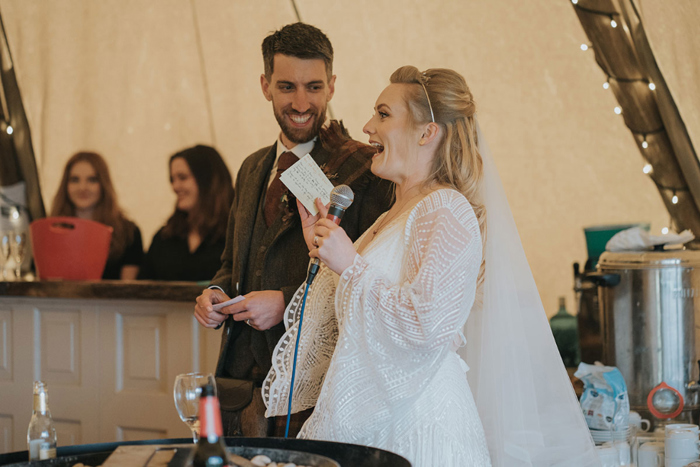 Bride and groom stand to do a speech