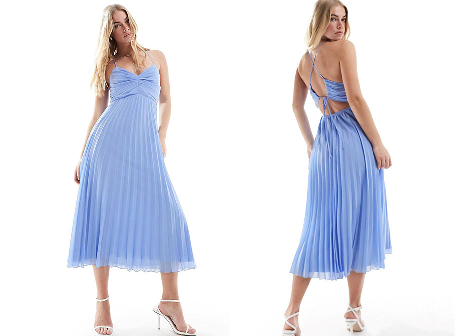 A woman wearing a midi blue chiffon dress with a pleated skirt and cross back strap