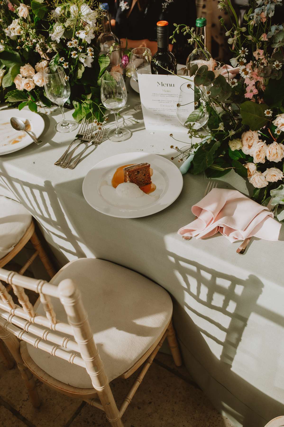Wedding breakfast dessert surrounded by flowers, glassware and pastel table styling at Ballogie House