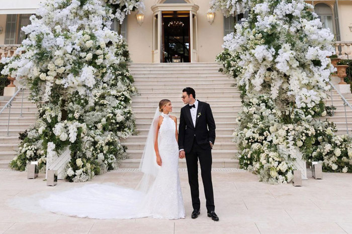Sofia Richie and Elliot Grainge stand in front of grand staircase during their wedding
