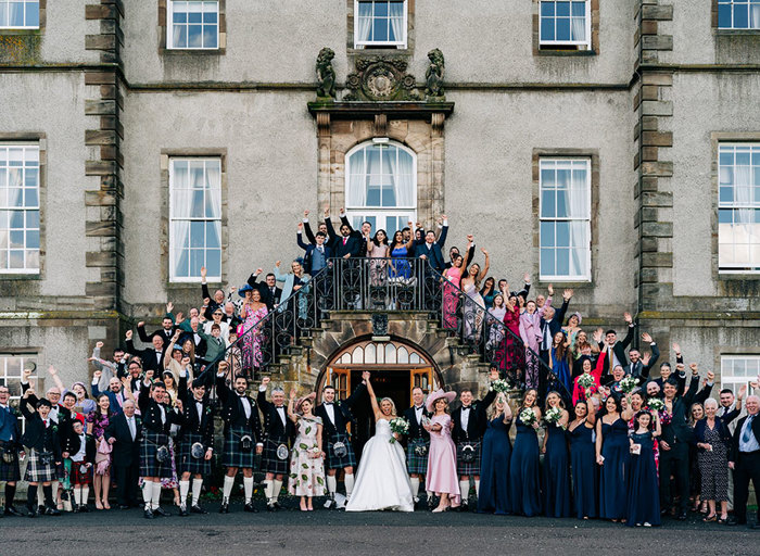 a wedding group portrait on an exterior stone staircase at Dalmahoy Hotel and Country Club