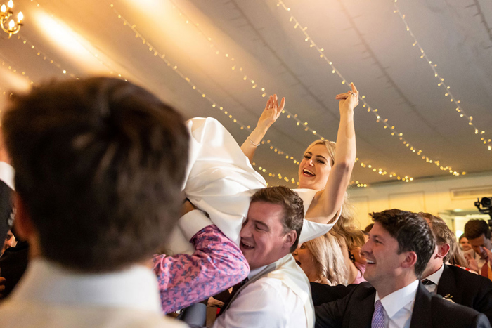 Bride is lifted by guests