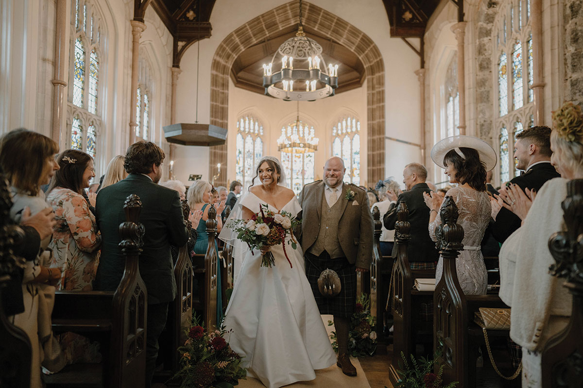 Bride and groom walking back up the aisle after their chapel wedding ceremony at Cluny Castle in Aberdeenshire.