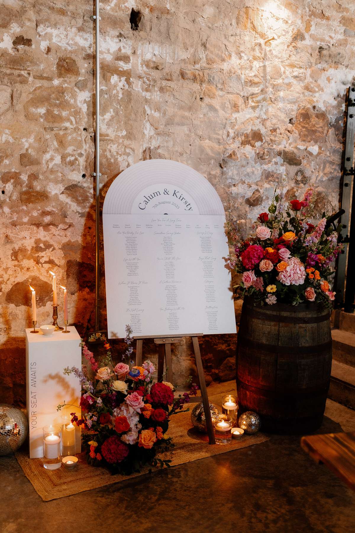 Wedding seating plan display with floral arrangements, candles and rustic styling at Falside Mill in Fife