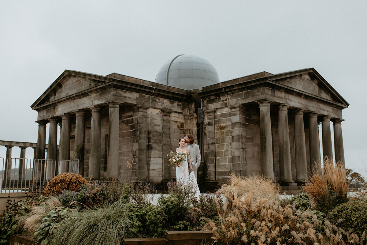 Couple standing in front of the neoclassical building at The Collective Edinburgh on Calton Hill