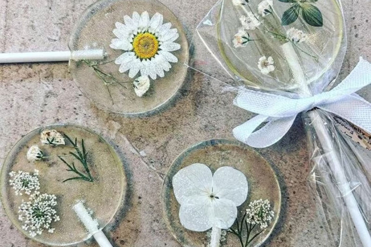 Clear lollipop wedding favours with pressed flowers and ribbon packaging