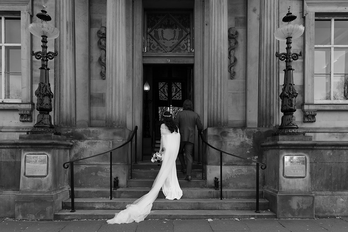 Bride and groom walking up the steps to the entrance of the Royal College of Physicians of Edinburgh