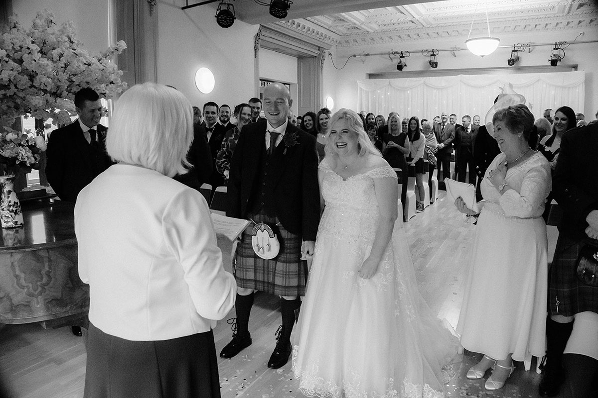 Couple holding hands and laughing during ceremony