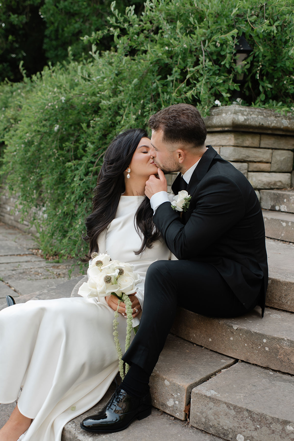 Bride and groom kissing on the stone steps at Carberry Tower during their intimate East Lothian wedding