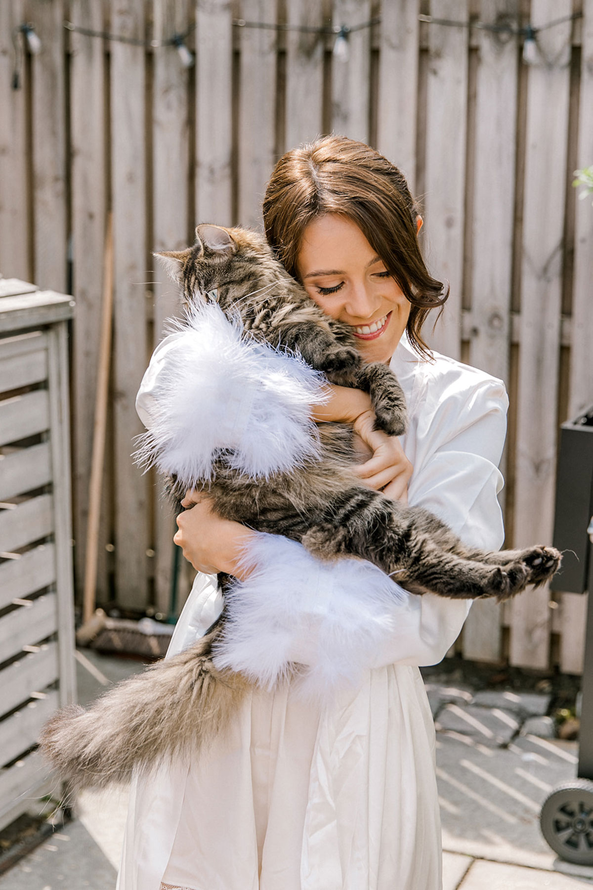 Bride cuddling her pet cat while getting ready on the morning of the wedding