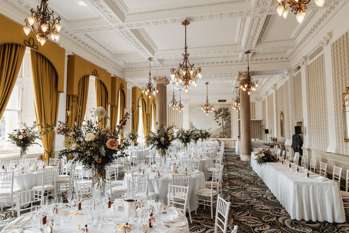Wedding breakfast setup in the Sir Walter Scott Suite at The Balmoral Edinburgh with floral arrangements and white table styling