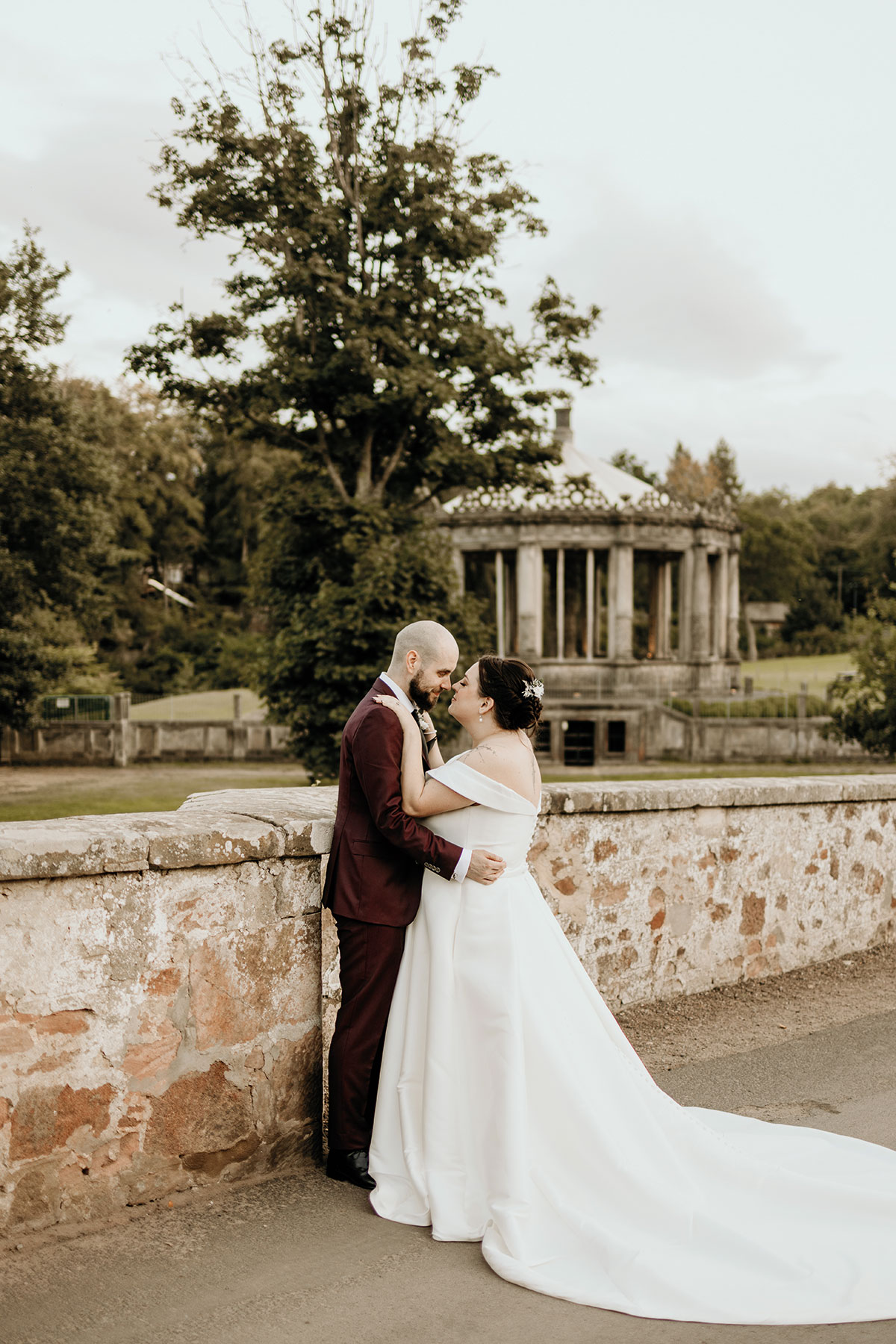 Bride and groom sharing a kiss during their wedding portraits at Restoration Yard in Dalkeith Country Park