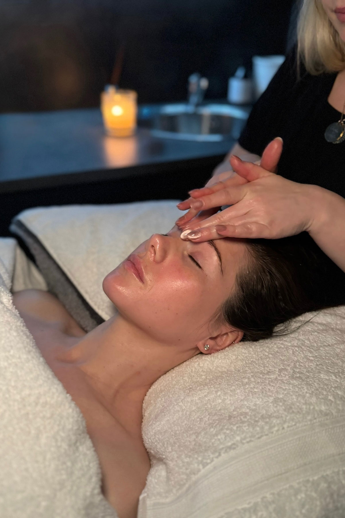 "Client receiving a soothing facial massage in a candlelit treatment room at FAB Salons