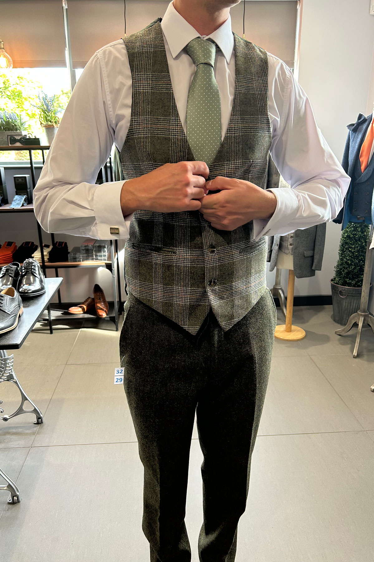 a person wearing a green checked waistcoat, tie and trousers