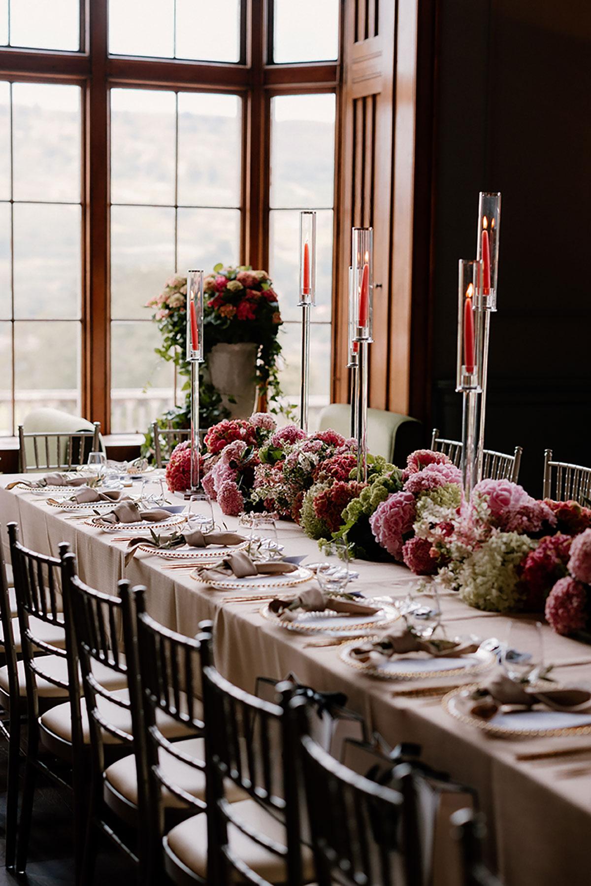 Elegant long wedding table at Mar Hall decorated with pink hydrangeas, tall candles and gold-rimmed place settings.