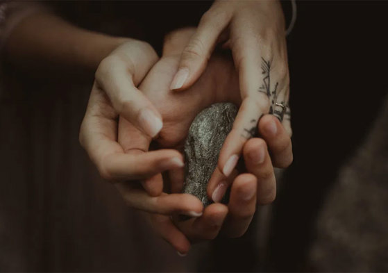 hands clasped around stone