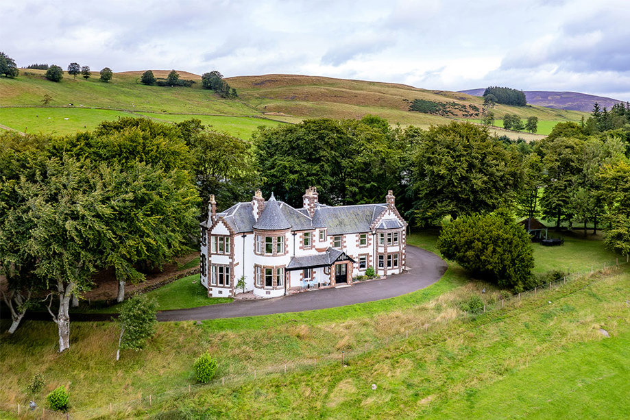 A house surrounded by trees and hills