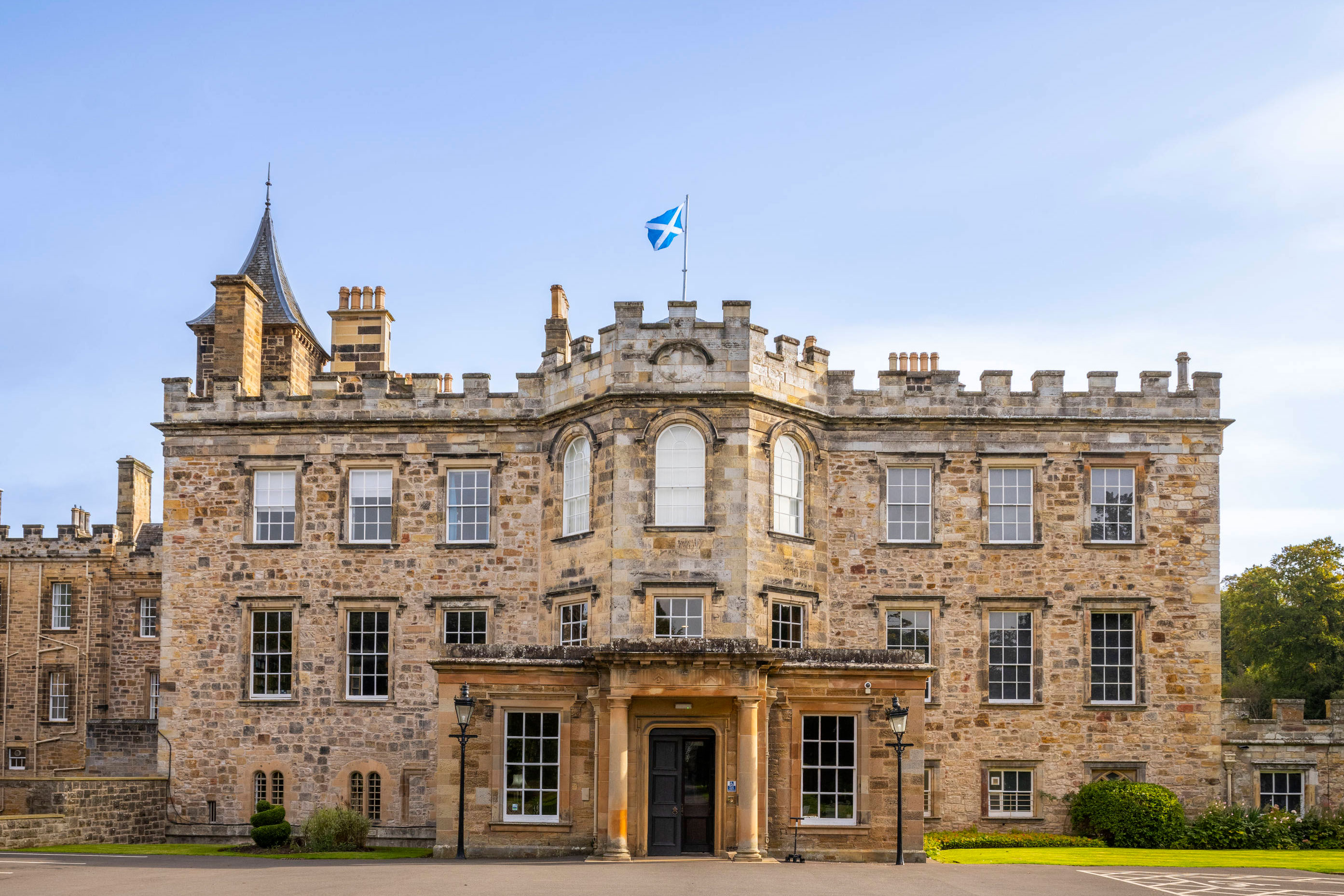 Exterior of Newbattle Abbey wedding venue in Midlothian with historic stone façade and Saltire flying above