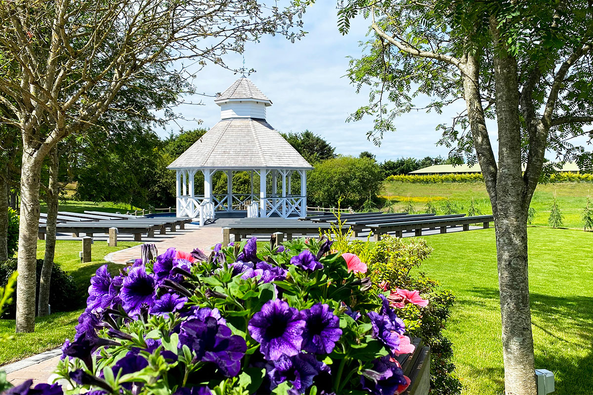 Outdoor wedding pavilion at The Gailes Hotel & Spa, surrounded by landscaped gardens and bench seating.