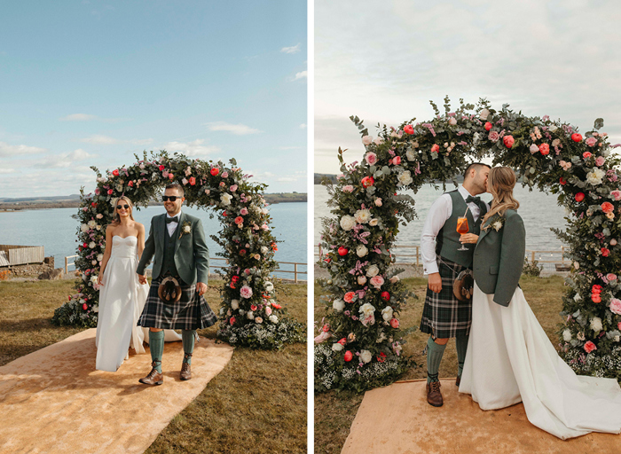 a bride and groom walking (left) and kissing (right) in front of a pink and white floral arch that's in front of a body of water