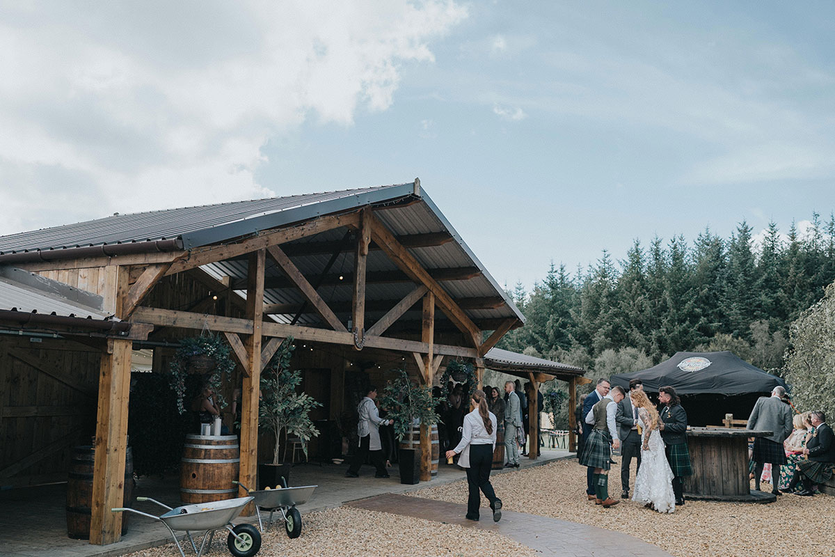 wedding guests stand outside eden leisure village for a drinks reception