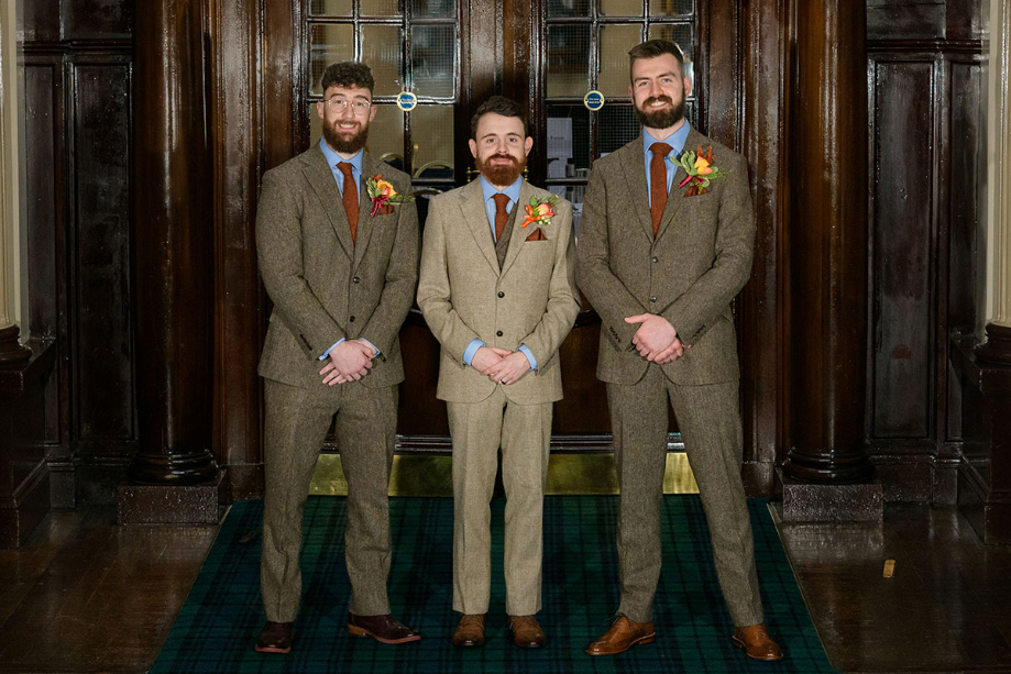 Groom and groomsmen in brown suits and autumnal buttonholes
