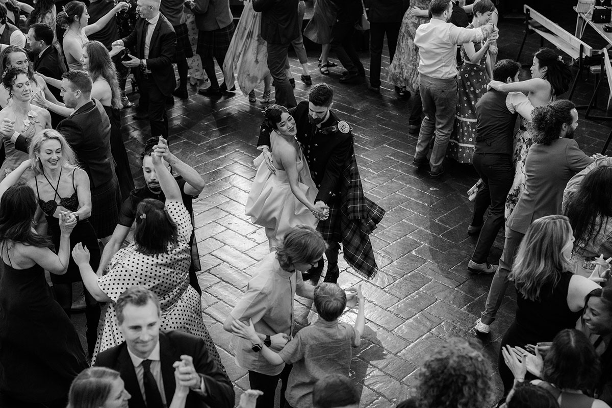 Guests ceilidh dancing at Barras Art and Design Glasgow wedding reception with crowded dancefloor