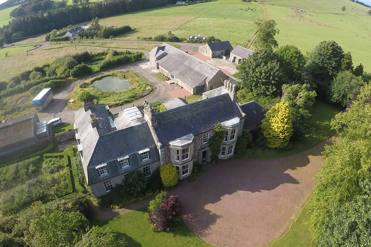 Aerial view of Cormiston Farm wedding venue showing the country house, farm buildings and surrounding countryside.