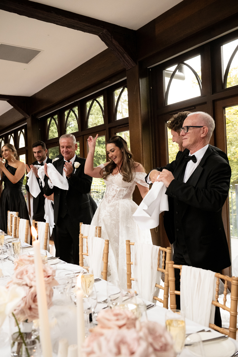 Bride celebrating with family at the top table during the wedding reception at Crossbasket Castle.