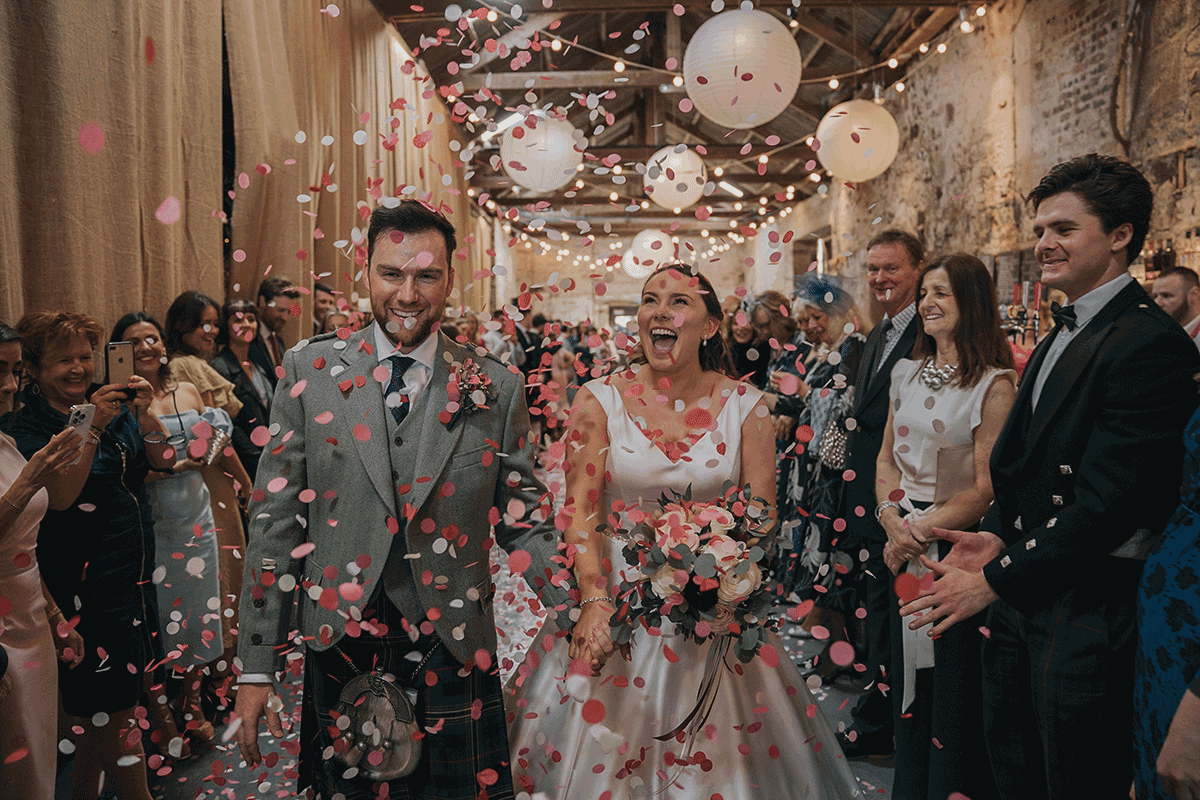 Couple walking through showers of pink confetti