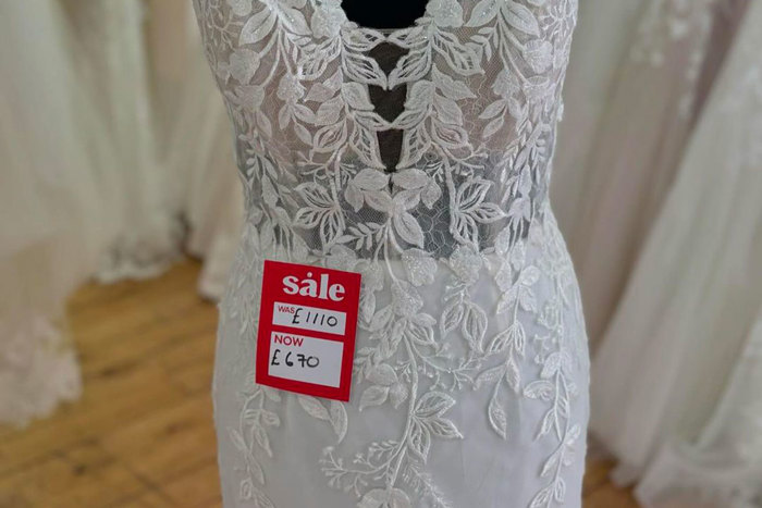 sparkly wedding dress on a mannequin with a red sale tag just below the bust