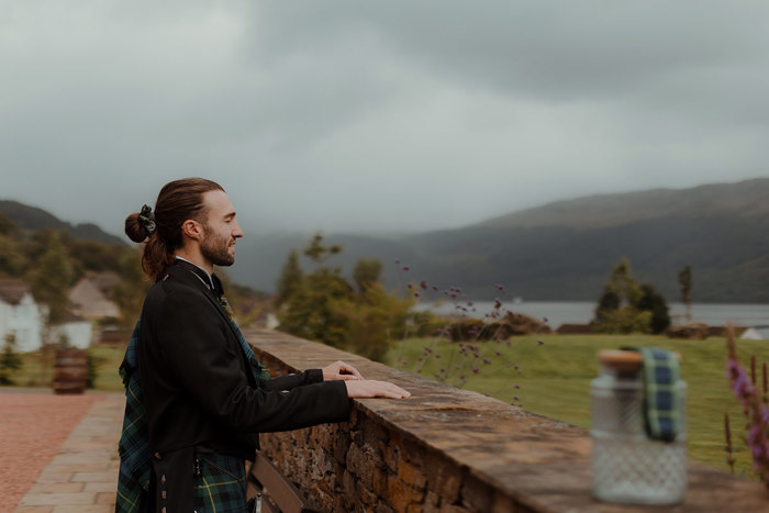 a groom looking out onto Loch Goil at Carrick Castle Estate wedding 