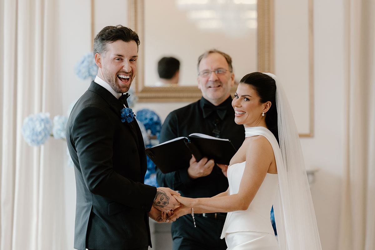 Wedding ceremony moment filled with laughter at The Exchange Glasgow as bride and groom hold hands