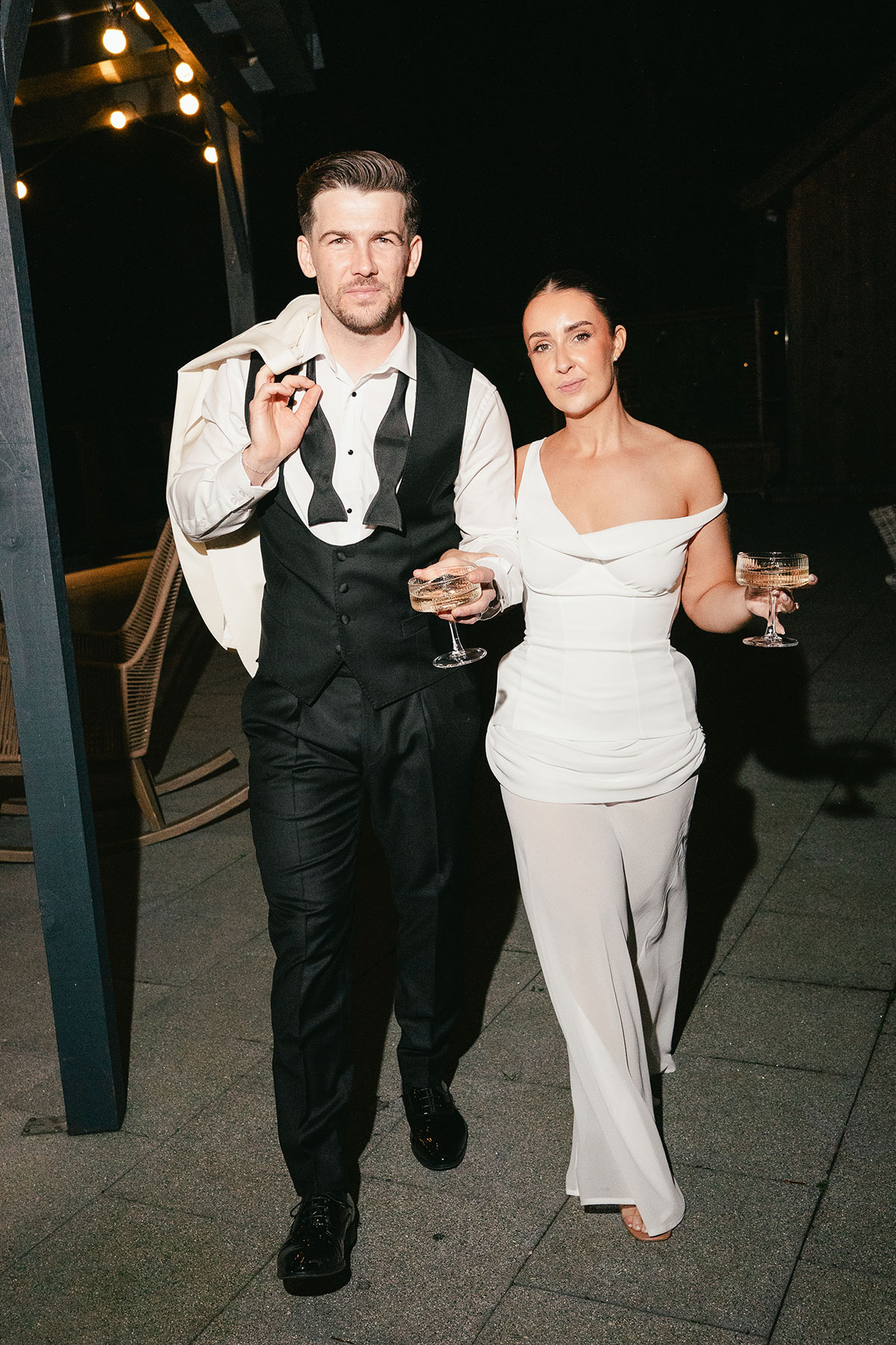 Bride and groom evening portrait walking with drinks during wedding reception at Enterkine Country House