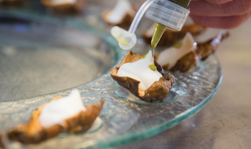 Decorating canapes with bottle of oil 