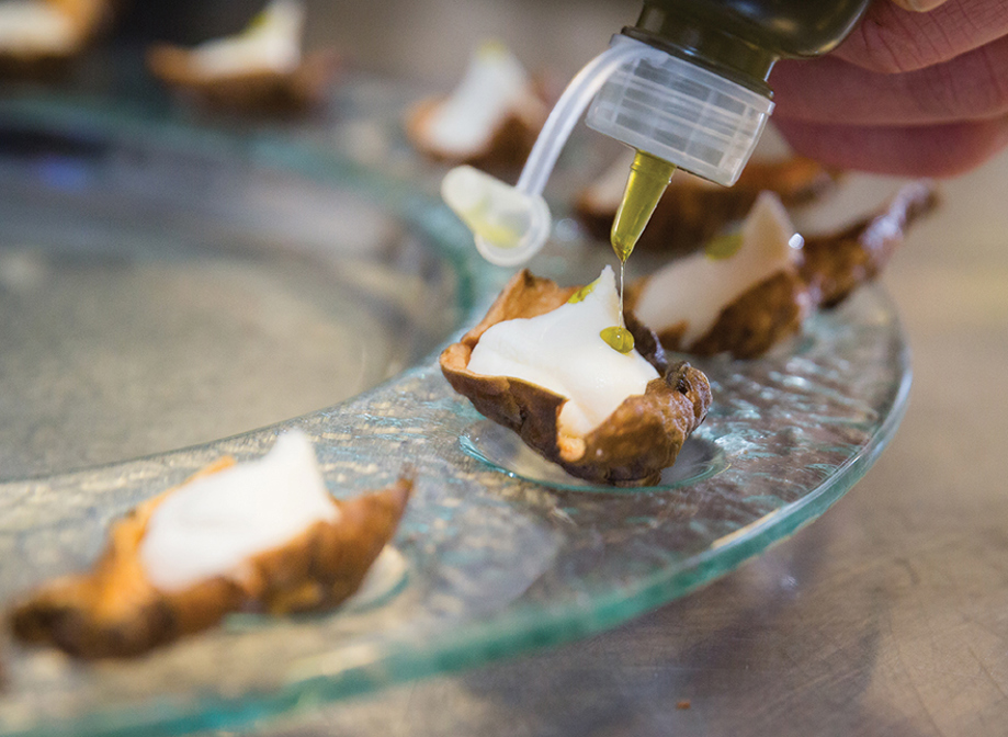 Decorating canapes with bottle of oil 