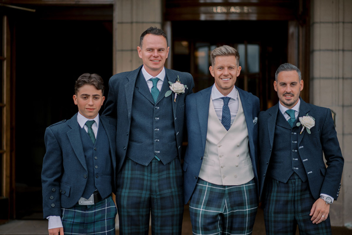 Groom and groomsmen in blue jackets and tartan trousers